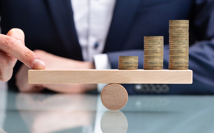 Businessperson Balancing Increasing Stacked Coins With Finger